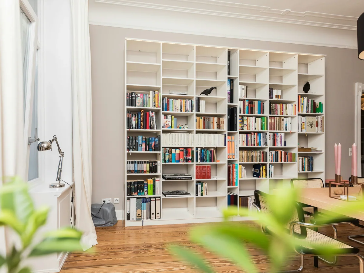 Solid hardwood shelving loaded with books, sized to limit deflection over a long span