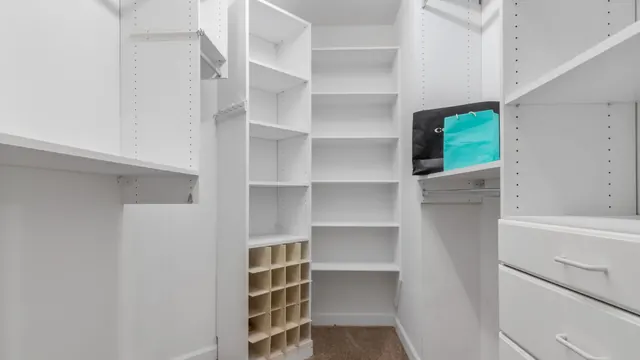 Custom walk-in closet system with double-hang sections and a drawer island in Lexington KY