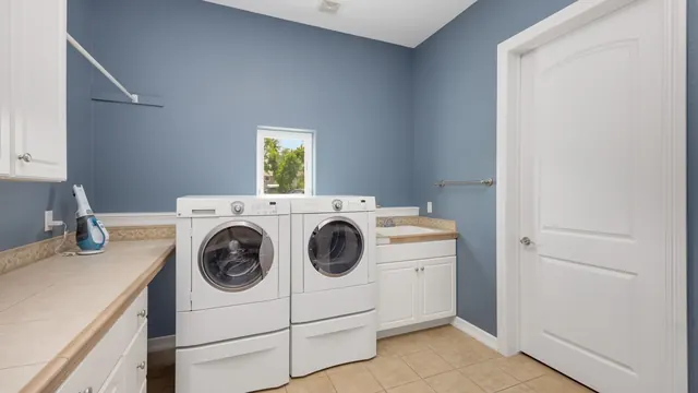 Custom laundry room cabinets with a folding counter and a pull-out hamper in Lexington KY