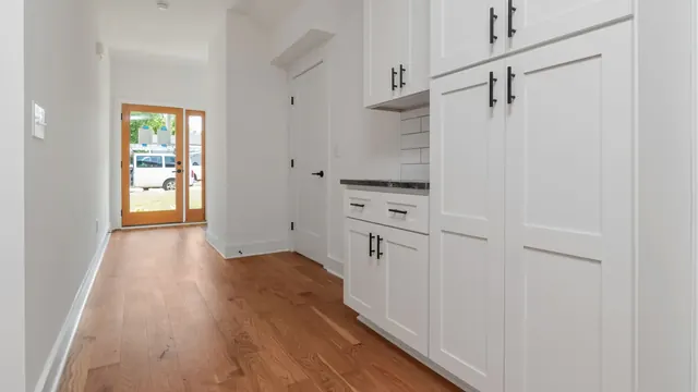 Custom mudroom lockers with a bench seat, coat hooks, and upper cubbies in a Lexington home