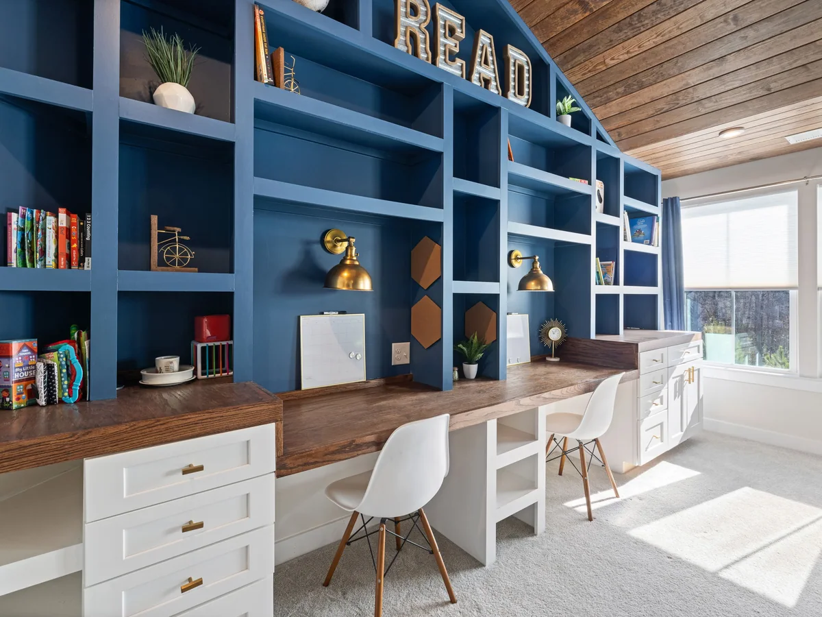 Low-reach toy bins and a wall-anchored bookshelf built into a child's bedroom
